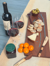 Load image into Gallery viewer, Turquoise-inlaid walnut serving board with bread, cheese, and olives beside two glasses of red wine
