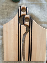Load image into Gallery viewer, Two custom wooden cutting boards with a light natural wood finish and dark black striped inlays, displayed on a textured beige linen background.