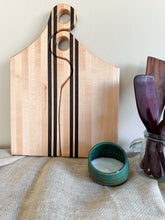 Load image into Gallery viewer, Two-piece maple and wenge charcuterie board set displayed upright beside a teal bowl and wooden utensils