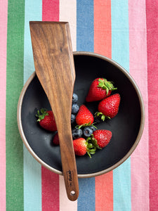 walnut handcrafted spatula pictured with a bowl of strawberries and blueberries