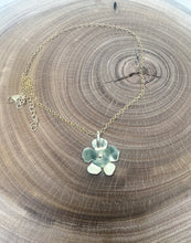 Load image into Gallery viewer, Necklace with a flower-shaped pendant on a wooden surface
