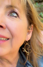 Load image into Gallery viewer, Close-up of a woman wearing brass butterfly line art earrings 
