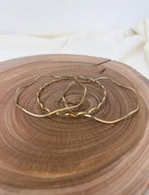 Load image into Gallery viewer, Stack of 3 brass  bracelet on a wooden surface with a white fabric background
