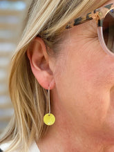 Load image into Gallery viewer, Circle drop earrings in apple green on a model
